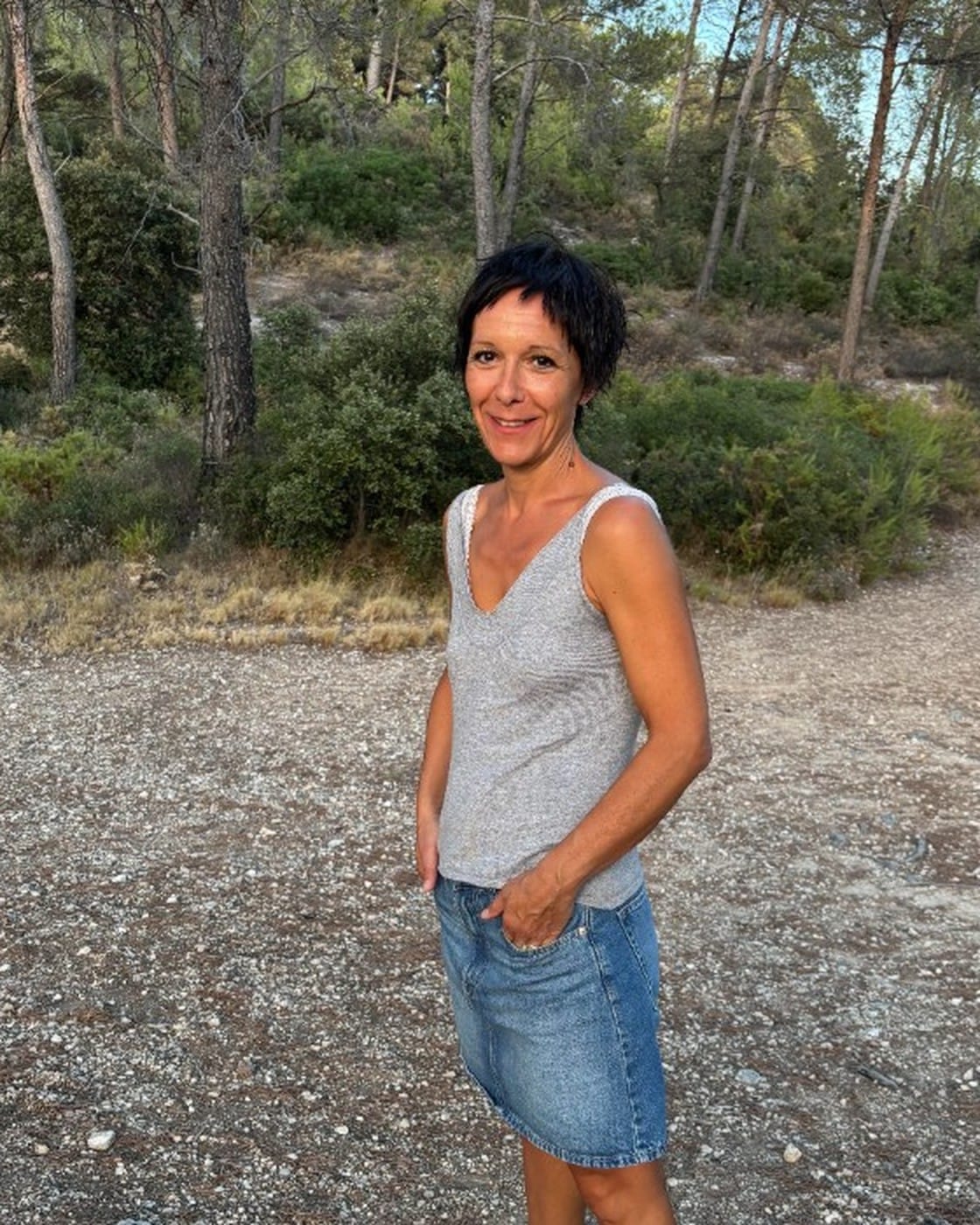 Pauline Gonzatto, souriante, sur un chemin de garrigue parmi les pins